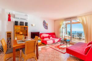 a living room with a red couch and a table at 180-degrees sea view with pool in Benitachell