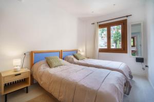 a bedroom with two beds and a window at Casa Yolima in Sóller