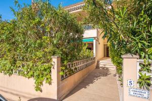 a house with trees in front of a fence at Casa Yolima in Sóller