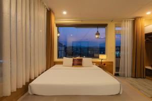 a bedroom with a white bed and a large window at Sweet Lavender Hotel - Ngay chợ đêm Đà Lạt in Da Lat +32 photos