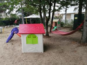 a small house with a red roof on a playground at Euroholiday Village 1G in Lido di Jesolo