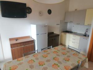 a kitchen with a table and a white refrigerator at Euroholiday Village 1G in Lido di Jesolo