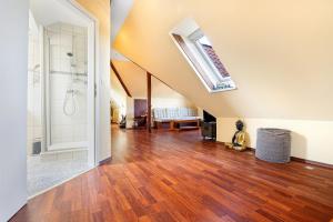 a large room with a shower and a wooden floor at Dachgeschosswohnung Wohllebe in Hannover +14 photos