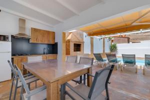 a kitchen and dining room with a wooden table and chairs at La Villa in Tarajalejo