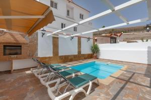 a patio with a swimming pool and a table and chairs at La Villa in Tarajalejo