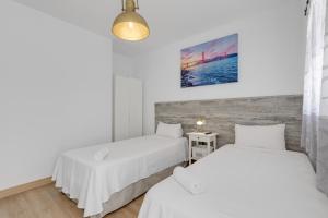 two beds in a room with white walls at La Villa in Tarajalejo +30 photos