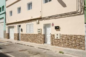 a white building with a door on a street at 2a Francesca in Vecindario