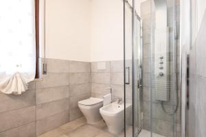 a bathroom with a toilet and a glass shower at Il grappolo monolocale in Sirmione