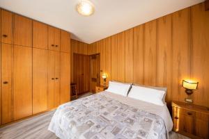 a bedroom with a large bed with wooden walls at Appartamento Primavera 1 in Moena