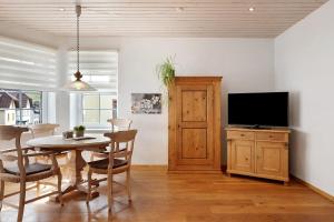 a dining room with a table and a flat screen tv at Ferienwohnung Dietsche Todtnau in Todtnau