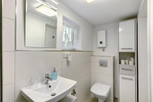 a white bathroom with a sink and a toilet at Fewo Schober in Kirchhundem +12 photos