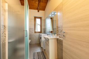 a bathroom with a sink and a toilet and a mirror at Chalet La Greta Vista Superiore in Firenzuola +37 photos