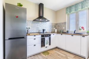 a kitchen with white cabinets and a stainless steel refrigerator at Brizna in Oreña