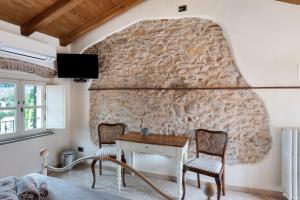 a room with a stone wall with a table and chairs at Antico Frantoio in Ceriale