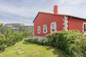 a red house with a yard in front of it at Brizna in Oreña