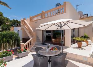 a patio with a table and an umbrella at Pescadores in Cala Ratjada
