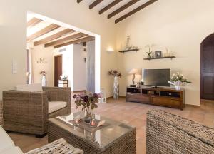 a living room with a television and wicker furniture at Pescadores in Cala Ratjada