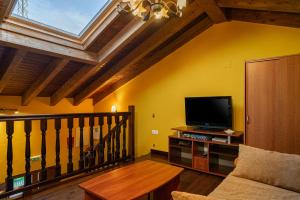 a living room with a couch and a tv at Apto Amarillo - Casa el gaitero in Susacasa