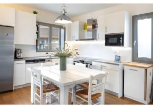 a white kitchen with a white table and chairs at Luna Rossa Milos - Olive Home in Provatas