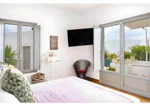 a bedroom with a bed and a tv on the wall at Luna Rossa Milos - Olive Home in Provatas +20 photos