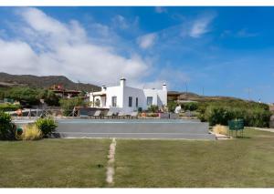 a white house with a lawn in front of it at Luna Rossa Milos - Olive Home in Provatas