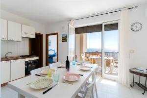 a kitchen and dining room with a white table and chairs at Olimpia's home in Otranto in Otranto