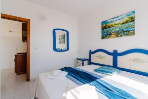 a bedroom with a blue and white bed in a room at Olimpia's home in Otranto in Otranto