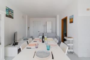 a white room with a table with a bottle of wine at Olimpia's home in Otranto in Otranto +19 photos