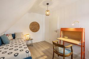 a bedroom with a bed and a desk and a table at Höhe26 in Bad Vilbel