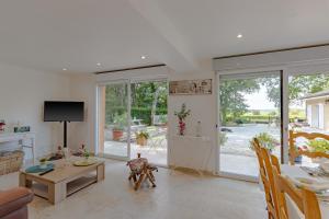 a living room with a table and a dining room at La Villa du Mas des Chenes in Pomport