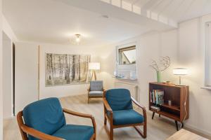 a living room with two chairs and a table at Höhe26 in Bad Vilbel