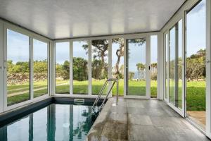 an empty house with a swimming pool with windows at Rocha do Mar 2 in Biscoitos