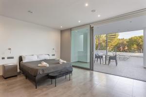 a bedroom with a bed and a balcony with a table at Villa Elite Maribiza in Cala Llena +24 photos