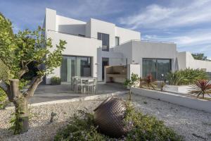 a white house with a courtyard with plants at Villa Elite Maribiza in Cala Llena