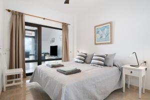 a white bedroom with a bed and a window at Apartamento Seaview Limones in Playa Blanca