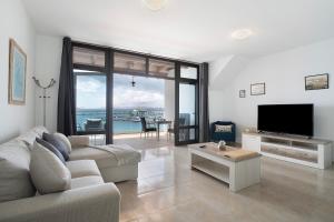a living room with a couch and a flat screen tv at Apartamento Seaview Limones in Playa Blanca