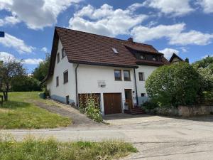 a white house with a brown roof at Ferienwohnung Birkenberger in Löffingen