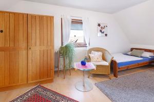 a bedroom with a bed and a chair and a table at Ferienwohnung Birkenberger in Löffingen