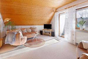 a living room with a couch and a tv at Ferienwohnung Birkenberger in Löffingen