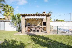 a backyard with a gazebo with a table at Casa Villanueva 2 - Sólo Familias in Conil de la Frontera