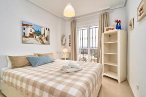 a bedroom with a bed with a checkered blanket at Balcon Bella Vista in Nerja +34 photos