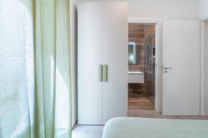 a bedroom with a door leading to a bathroom at La Casetta del Cuore in Noto +26 photos