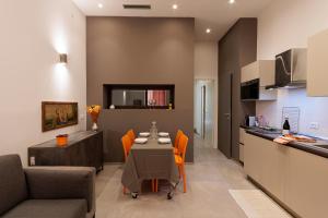 a kitchen and dining room with a table and chairs at La Casetta del Cuore in Noto