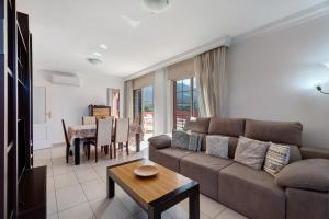 a living room with a couch and a table at terrazas del duque fase2 in Adeje
