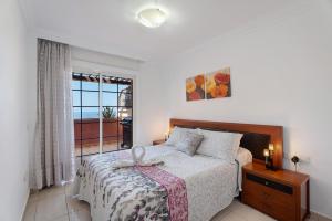 a bedroom with a bed and a large window at terrazas del duque fase2 in Adeje +24 photos
