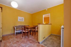 a dining room with yellow walls and a table and chairs at Rosaspina - Appartamento 6 in Capalbio