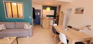 a living room with a couch and a table at L'appartement De La Forêt in La Tranche-sur-Mer +3 photos