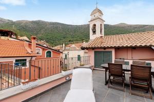 a balcony with a table and chairs and a church at Antico Frantoio in Ceriale