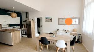 a kitchen and dining room with a table and chairs at L'appartement De La Forêt in La Tranche-sur-Mer