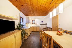 a kitchen and dining room with a table and a television at Wohnung Gravensteiner Schnalserhof in Laces +11 photos